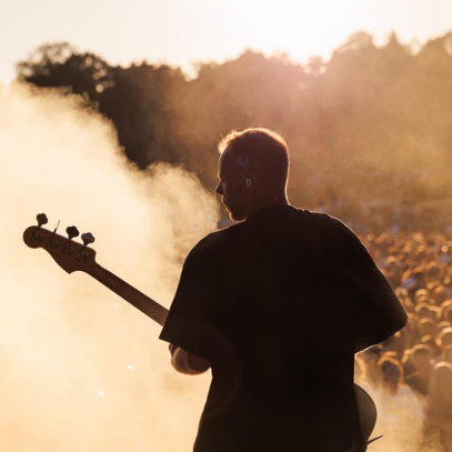 Gitarzysta na plenerowej scenie podczas występu.