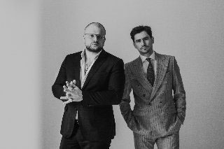 Panowie stykają się ramionami.