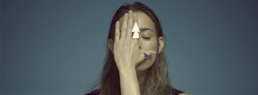 na zdjęciu kobieta zakrywa twarz dłonią
