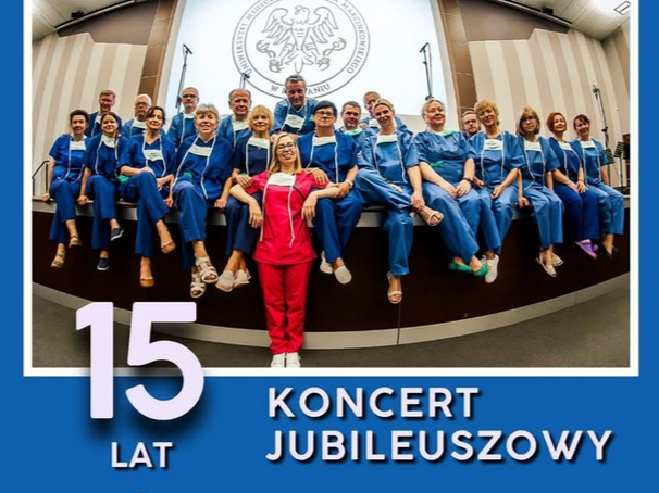 Grupa osób ubranych w niebieskie stroje lekarskie siedzi w rzędach, przed nimi jedna osoba w czerwonym stroju.