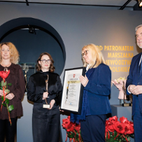 Laureatki odbierają nagrody, w rękach kwiaty, statuetka, obok wręczający