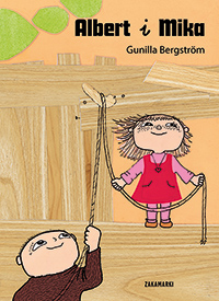 Okładka książki. Dwóch bohaterów chłopiec i dziewczynka. Oboje są przedstawieni w radosnych pozach, z uśmiechami na twarzach. Albert trzyma sznurek, którym steruje, podczas gdy Mika bawi się w tle. Okładka ma jasne, ciepłe kolory.