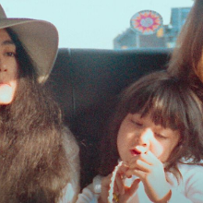 Para hipisów, John Lennon i Yoko Ono, jadą samochodem ze swoim małym synkiem.