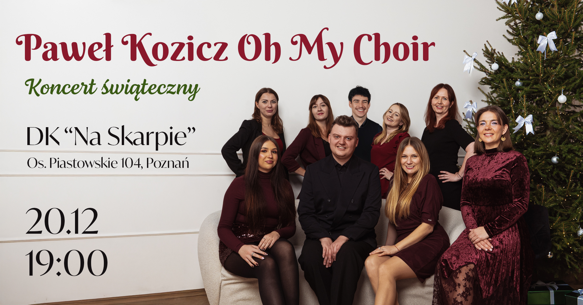 Zespół muzyczny składający się z dwóch mężczyzn i siedmiu kobiet. Mężczyźni ubrani w czarne koszule i spodnie. Kobiety ubrane w bordowe sukienki. Wszyscy się uśmiechają i pozują do zdjęcia na tle przystrojonej choinki.