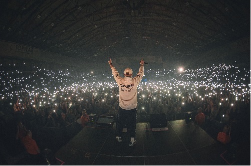 Wieczór. Pezet na scenie. Przed nim publiczność z włączonymi latarkami smartfonów.