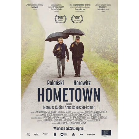 Ryszard Horowitz i reżyser Roman Polański idą ścieżką, w rękach trzymają paraslki.