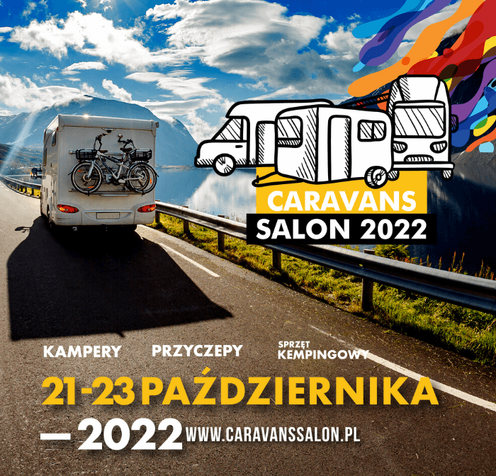 Kamper jadący drogą wśród górskich szczytów.