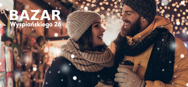 Kobieta i mężczyzna w zimowych straojach uśmiechają się do siebie, a w ręku mają kubki na gorące napoje.