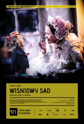 Zdjęcie kobiety w starodawnym białym czepku na głowie i koronkowej białej sukni; naprzeciw kobiety lalka z bujnymi włosami i małym słomkowym kapeluszu na głowie. U dołu zdjęcia napisy, w tym tytuł spektaklu.