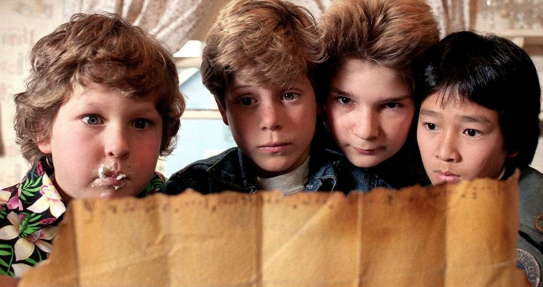 Czterech chłopców trzyma mapę i przygląda się jej z niepokojem.