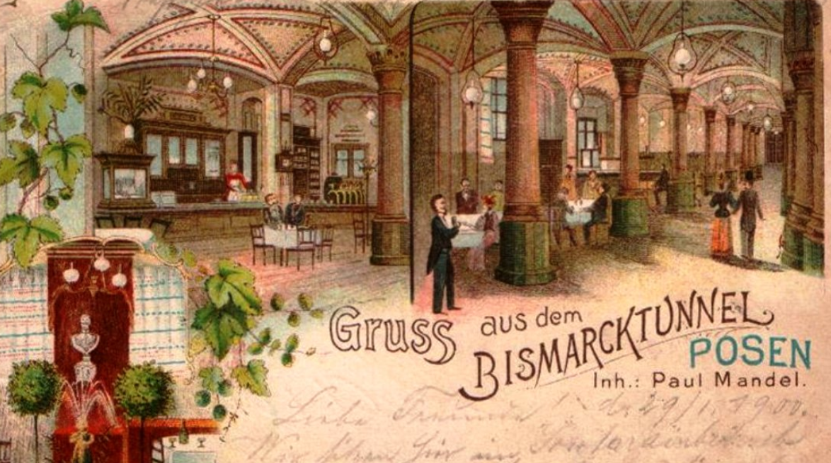Grafika starej restauracji, z ozdobnym sufitem i wiszącymi lampami. Goście restauracji ubrani w eleganckie stroje. Napis na grafice Gruss aus dem Bismarcktunnel Posen.