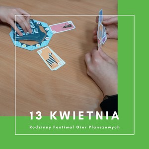 widok stolu i dwoch osób grających w grę planszową