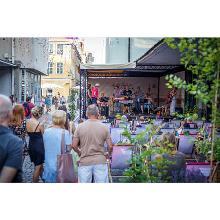 Koncert, scena na ul. Quadro, widzowie siedzą na leżakach i stoją