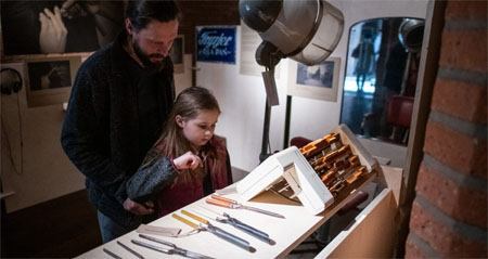 Dziewczynka najprawdopodobniej z ojcem ogląda narzędzie (np: dłuta)
