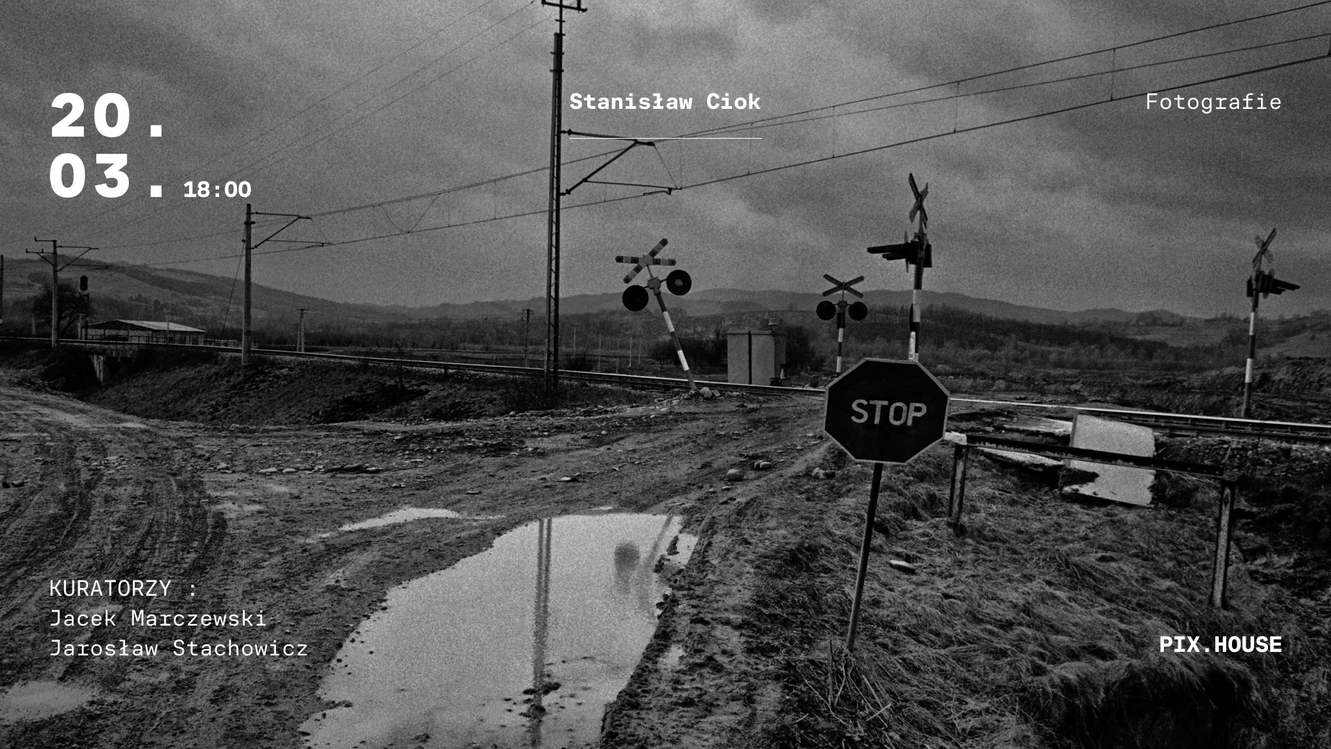 Informacje o wystawie fotografii Stanisława Cioka, czarno-białe zdjęcie zaniedbanego przejazdu kolejowego w pagórkowatym krajobrazie.