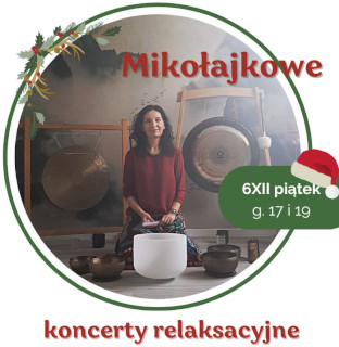 Zdjęcie przedstawia kobietę siedzącą przed dużym gongiem oraz kilkoma misami do śpiewu. Kobieta ma na sobie czerwoną koszulkę. Gong jest zawieszony na suficie za kobietą. Misy do śpiewu są ułożone w półkolu przed nią. Tło stanowi biała ściana. Kobieta ma ciemne włosy i patrzy w obiektyw aparatu. Kobieta lekko się uśmiecha.