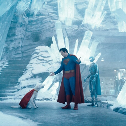 Superman z superpsem w lodowej jaskini. Obok nich robot.