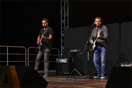 Muzycy z gitarami na scenie