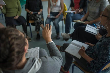 Uczestnicy warsztatów folkowych siedzą w kregu