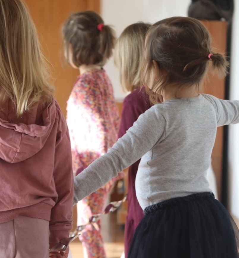 Tańczące dzieci odwrócone tyłem do kamery.