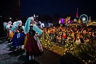 Na zdjęciu artyści w strojach ludowych stoją na scenie przed publicznością.