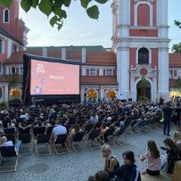 Widzowie oglądają film na dziedzińcu Urzędu Miasta Poznania.