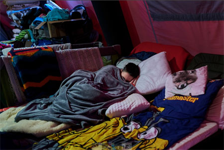 Najprawdopodobniej kobieta śpi pod kocem w jakim miejscu dla uchodźców.