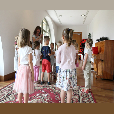 Grupa dzieci i animatorka w bawialni