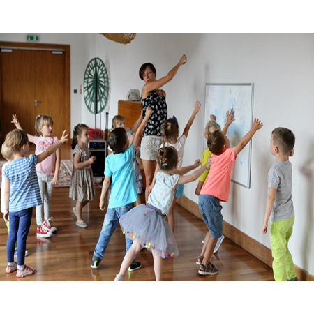 Grupa dzieci i animatorka w bawialni