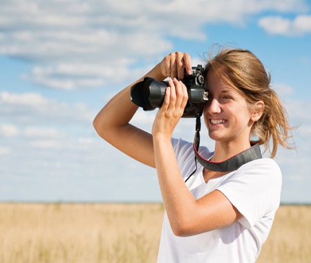 Dziewczyna z aparatem na łące