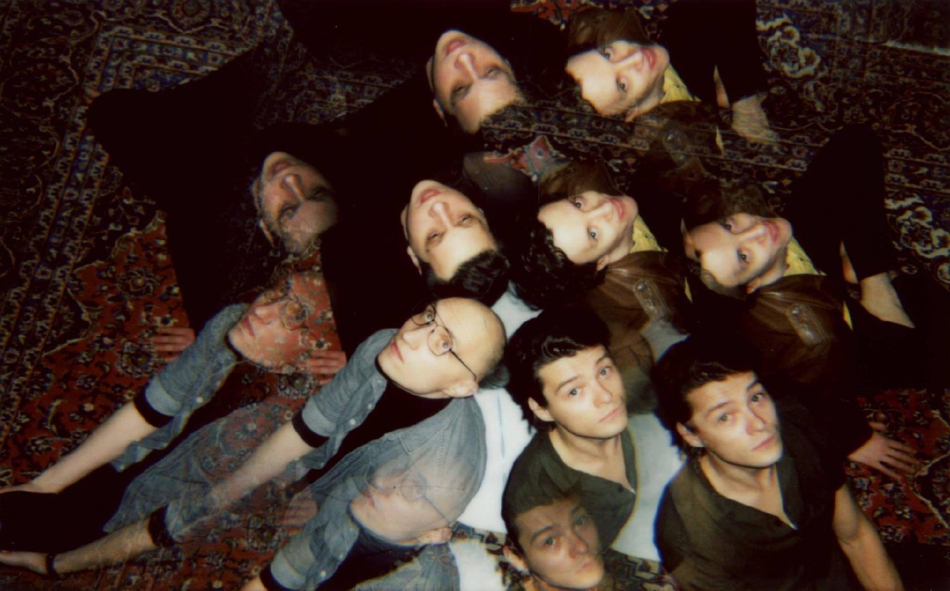 Na zdjęciu twarze kilku osób patrzących w górę.