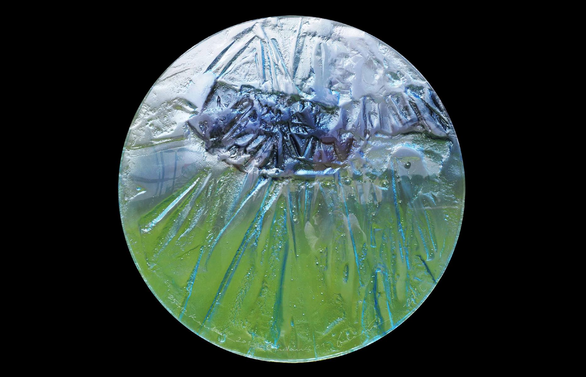 Na zdjęciu na czarnym tle okrąg ze szkła w dolnej części zielonkawy w górnej niebieski.