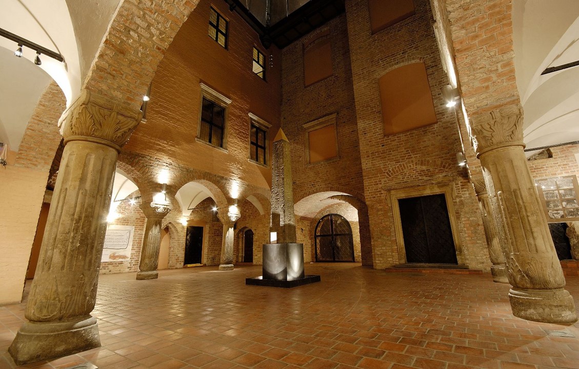 Zdjęcie oświetlonego dziedzińca Muzeum Archeologicznego. W centralnej części obelisk Ramzesa II.