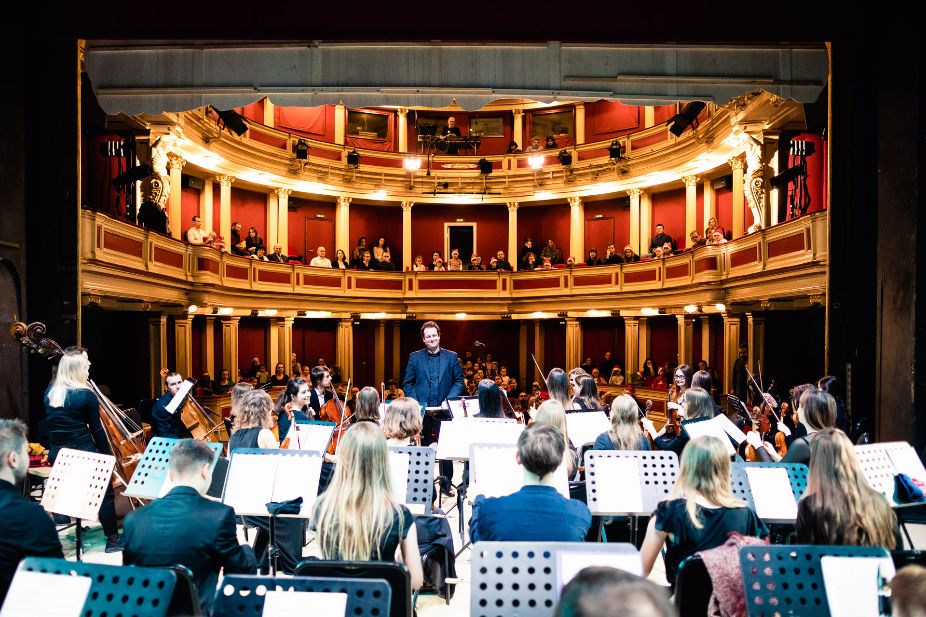 Zdjęcie pokazuje orkiestrę i widownię Teatru Nowego. Zdjęcie zrobione z ostatniego rzędu w orkiestrze.