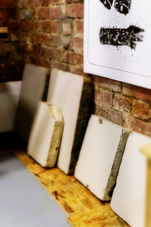 Zdjęcie przedstawia ułożone obok siebie kamienie litograficzne, służące za matryce wykorzystywane w druku litograficznym.