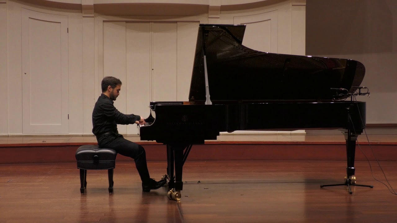 Na zdjęciu mężczyzna siedzący przy fortepianie.