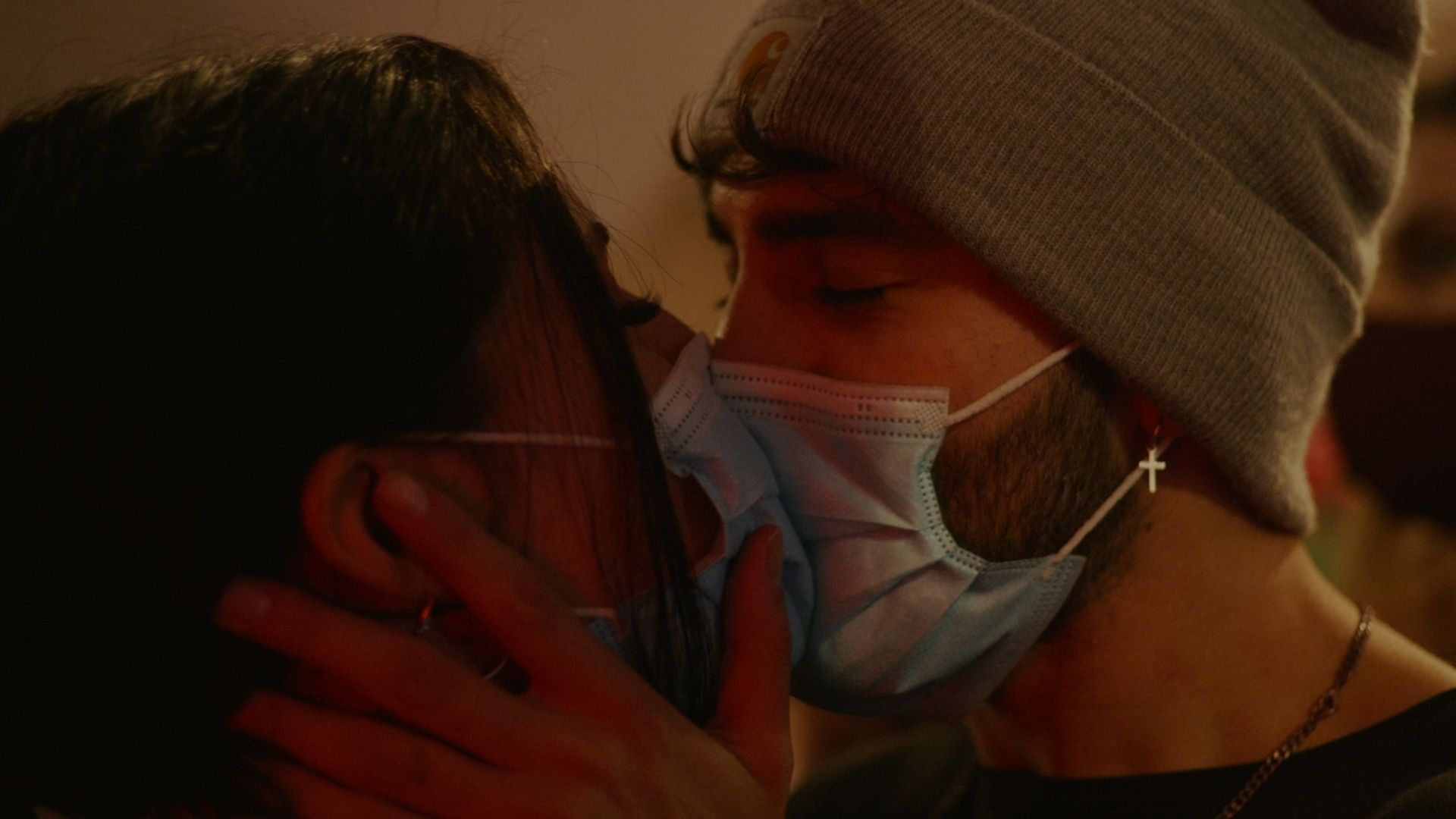 Na zdjęciu całujące się dwie postaci w maseczkach.