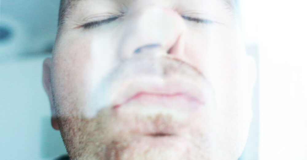 Mężczyzna całuje szybę, przyciskając do niej twarz. Widzimy to zza szyby.