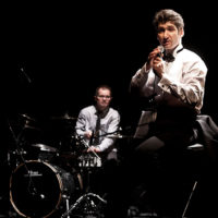 Na zdjęciu dwóch członków zespołu na scenie.