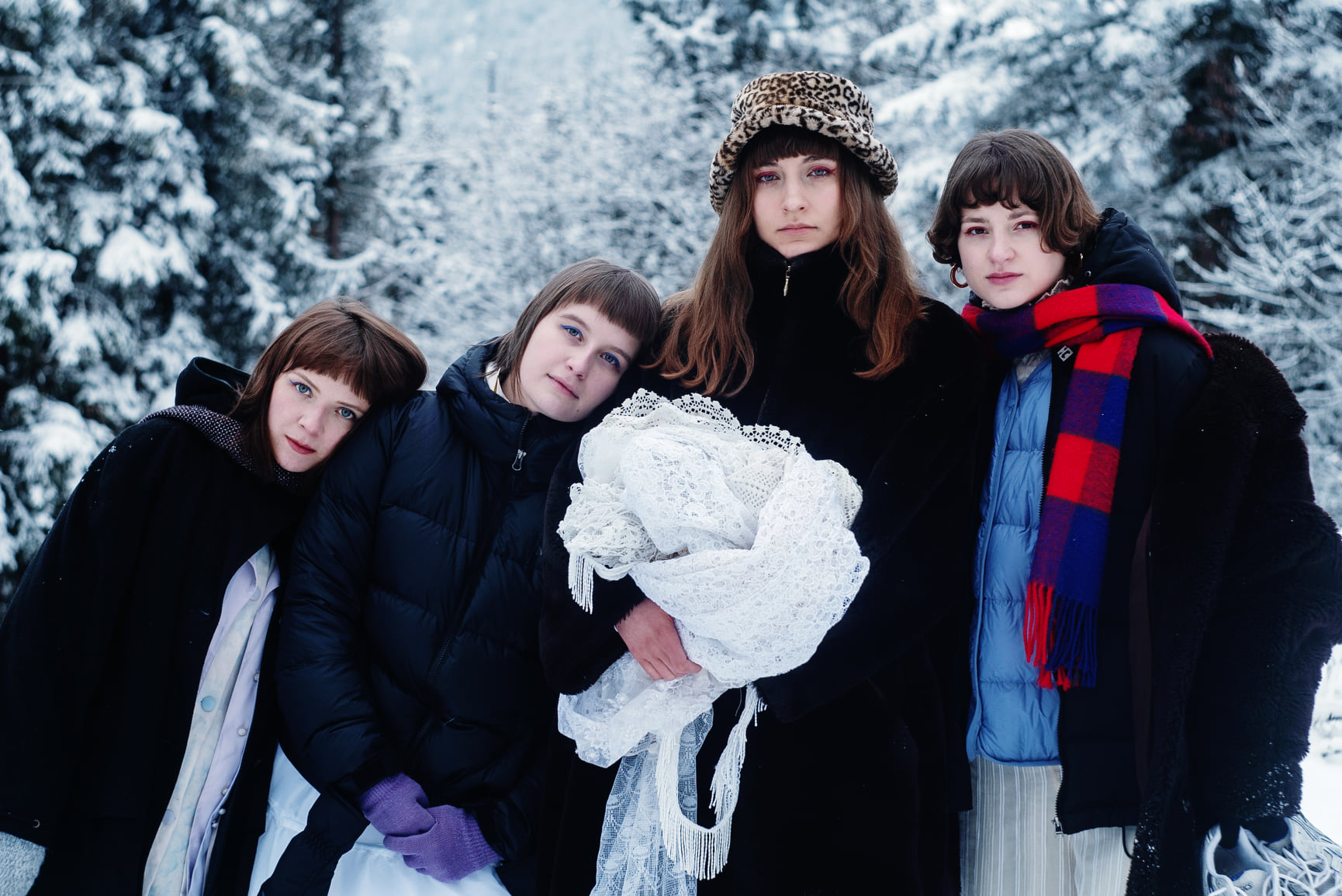 Cztery młode dziewczyny w zimowej scenerii.