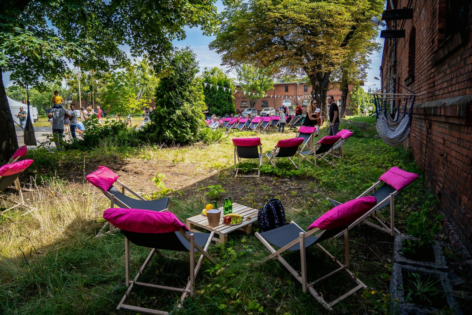 Na zdjęciu fragment byłych koszar. Na pierwszym planie rozłożone leżaki na trawie.