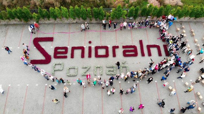 Zdjęcie seniorów wokół napisu "senioralni Poznań".