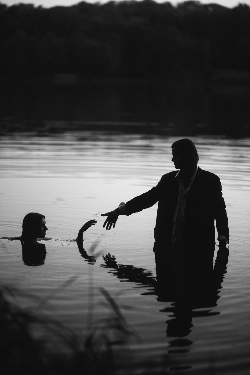 Na czrno-białym zdjęciu postaci kobiety i mężczyzny w wodzie.