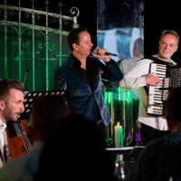 Na zdjęciu trzyosobowy zespół muzyczny na scenie.