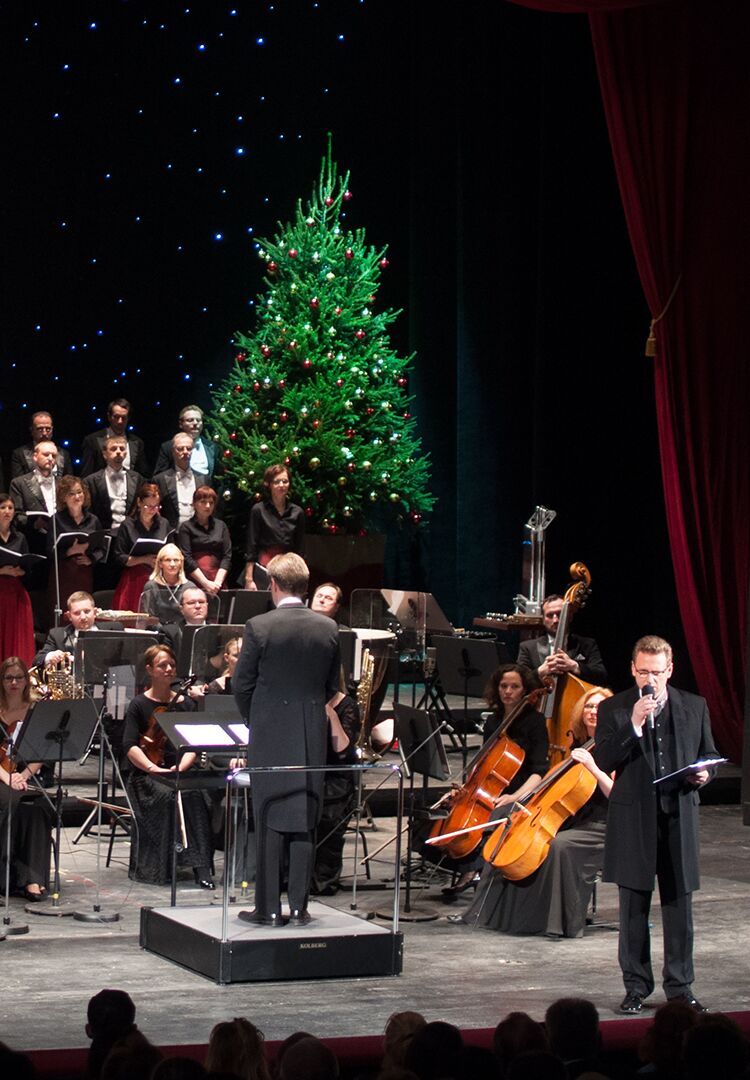 Na zdjęciu scena z operze poznańskiej z orkiestrą i choinką na środku.