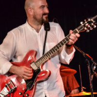 Na zdjęciu Danny Handley z gitarą.