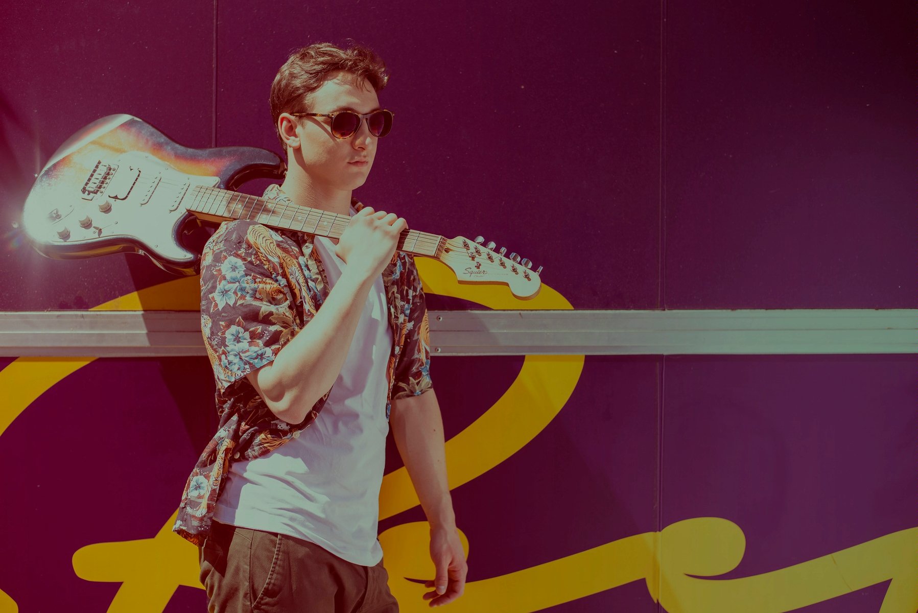 Na zdjęciu Wojtek idący z gitarą na ramieniu.