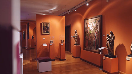 zdjęcie z wystawy "Jan z Lubrańca"; na zdjęciu widoczne obrazy, rzeźby oraz mniejsze eksponaty