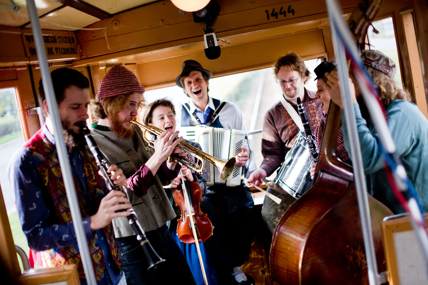 Zdjęcie członków zespołu grających wewnątrz starego tramwaju.