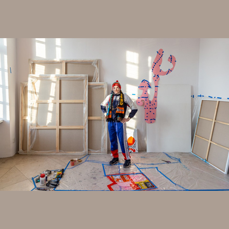 Przemysław Piniak w swojej pracowni. Mężczyzna patrzy prosto w obiektyw.